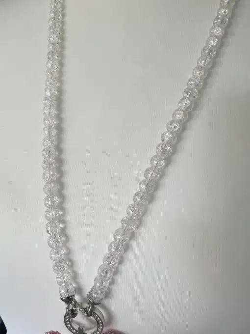 Wechsel Kette Halskette aus Glasperlen mit kreisförmigem Anhänger auf weißem Hintergrund.