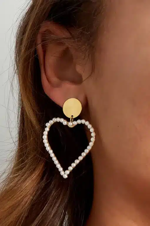 Eine Frau trägt einen Perl Herz Ohrstecker mit herzförmigem Design.