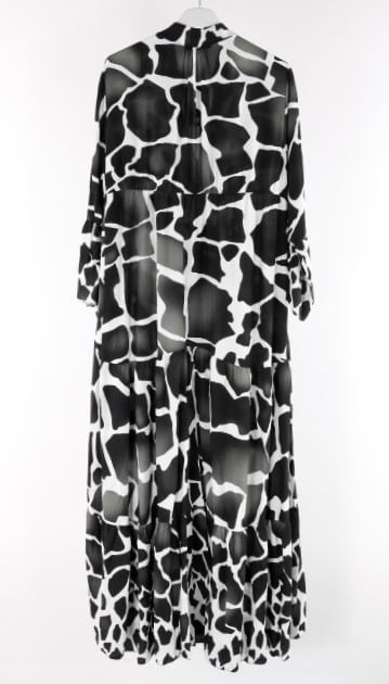 Ein Maxikleid mit einem schwarz-weißen Giraffenprint, das an einem Kleiderbügel hängt.