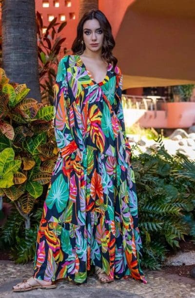 Eine Frau trägt ein farbenfrohes Maxikleid mit tropischem Print und einem Panama-Boho-Kleid-Flair (Kopie), das an den Boho-Kleid-Stil erinnert.