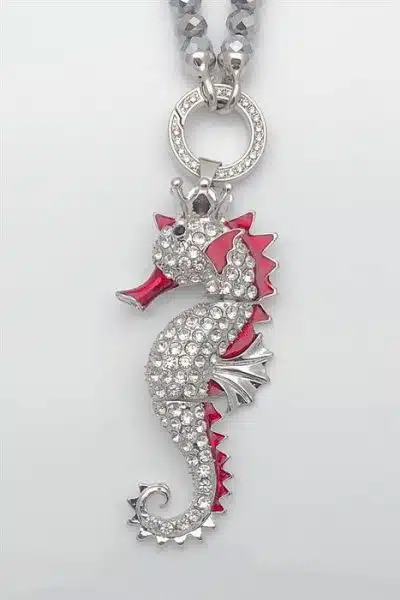 Eine silberne Seepferdchen-Halskette mit roten und weißen Kristallen, erhältlich als Geko-Wechselanhänger (Kopie).
