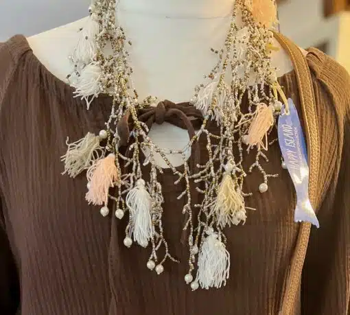 Eine Halskette mit Quasten und Perlen an einer Schaufensterpuppe, die eine Isla Ibiza-Kette trägt.
