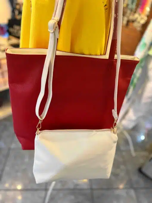 Eine rote Dubble Herisson Shopper-Tasche mit einer weißen Umhängetasche, die vorne hängt.