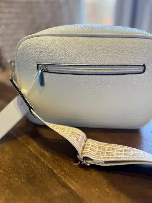 Eine weiße Umhängetasche von DC Tasche mit einem Etikett darauf.