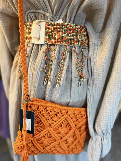 Eine orangefarbene Janisa Flex Gürtel (Kopie)-Tasche mit einer Quaste darauf.
