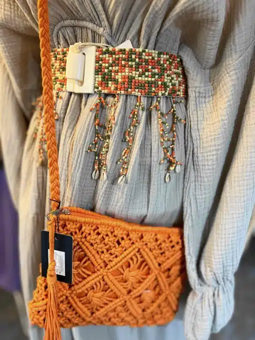 Eine orangefarbene Janisa Flex Gürtel (Kopie)-Tasche mit einer Quaste darauf.