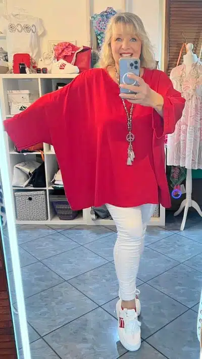 Eine Frau macht ein Selfie in einer roten Simple Basic Tunika XL und einer weißen Hose.