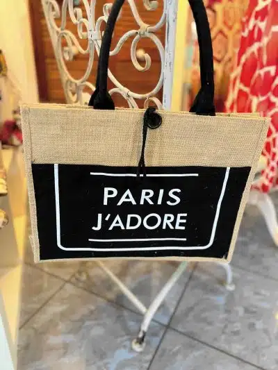 Eine Paris j‘adore Tasche auf einem Metallständer.