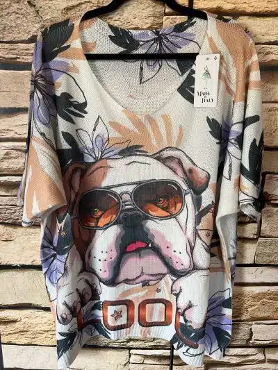 Ein grafisches T-Shirt mit einer Bulldogge mit Sonnenbrille und einem Light Dog's Pulli vor einer Backsteinmauer im Hintergrund.