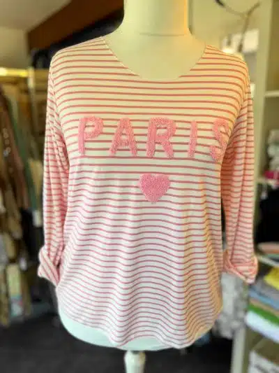 Rot-weiß gestreiftes, langärmliges rosafarbenes Paris-Streifenhemd mit der Aufschrift „Paris“ in rosa und einem herzförmigen Detail.