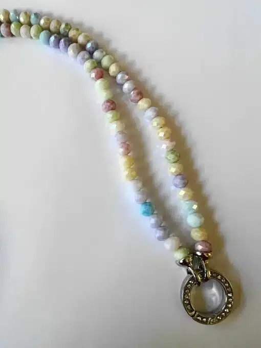 Mehrfarbige Perlenkette mit rundem Anhänger auf weißem Hintergrund.