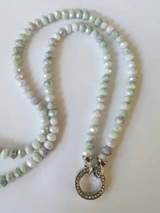 Perlmuttfarbene Perlenkette mit rundem Anhänger.