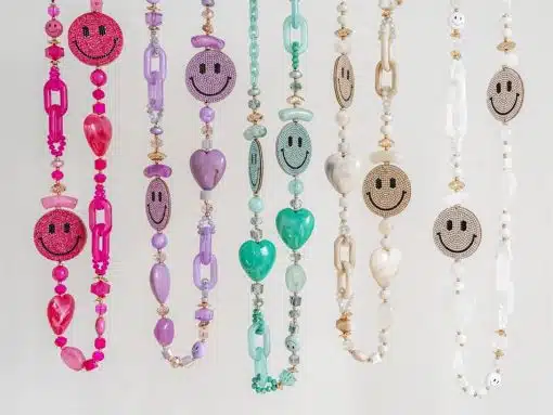 Eine Auswahl an Love Smile Ketten mit Anhängern in Form von Smileys, die vor einem hellen Hintergrund Liebe ausstrahlen.