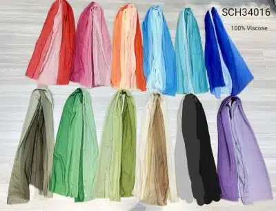 Eine Reihe farbenfroher Basic Schals aus 100% Viskose, ordentlich angeordnet und ausgebreitet auf einem hellgrauen Hintergrund. Ein Basic Schal ist mit einem schwarzen Balken zensiert.