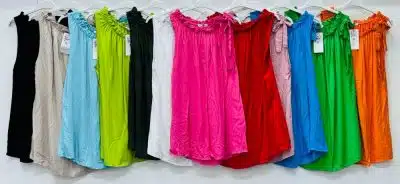 Satz mit Ersatz: Eine Auswahl farbenfroher Kleider von Zara, jedes mit einzigartigen Strukturdetails, hängen in einer Reihe auf einem Kleiderständer vor einem weißen Hintergrund.