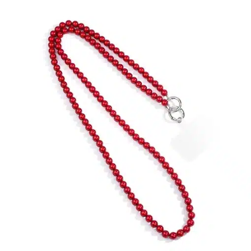 Eine Magic Beads Handy-/Taschenkette, mit leuchtend roten Perlen und einem weißen Identifikationsschild an einem silbernen Verschluss, ist in lockerer, geschwungener Anordnung auf weißem Hintergrund zu sehen. Die Komposition strahlt die Eleganz einer kunstvollen Taschenkette aus.