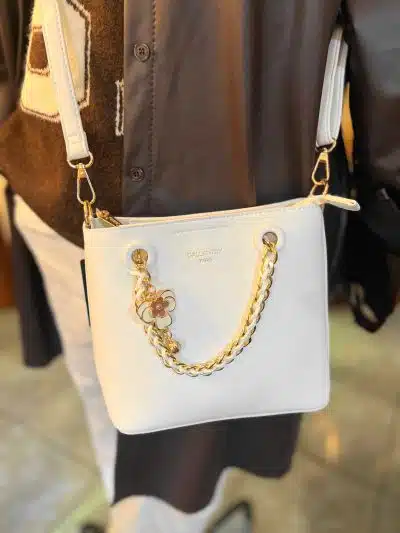 Setze mit der Best Friend White Shoulder Bag ein Statement: Trage sie crossbody, goldene Kette & Blumen-Charm runden deinen Look ab.