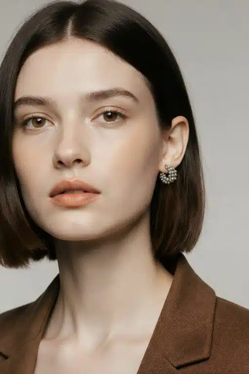 Setz ein Statement mit deinem Look: Kurzes braunes Haar, brauner Blazer und auffällige Aurora Hoops aus Silber - mutig und modern.