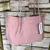 Stell dir vor, du trägst eine stylische Handtasche in einem angesagten Textur-Pink – ein echter Hingucker! Die zwei praktischen Träger machen sie zum perfekten Begleiter für deinen Alltag. Vor einem coolen Steinmuster-Hintergrund kommt dieses Fashion-Statement besonders gut zur Geltung. Noch besser: Am Träger baumelt ein schickes weißes Tag, das den Look komplettiert und dir einen Hauch von Exklusivität verleiht. Greif zu und mach diesen Trend zu deinem eigenen!.