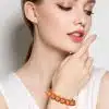 Entdecke deine innere Ruhe und strahle Gelassenheit aus! Stell dir vor: Du, mit deinem schönen langen Haar und dezentem Make-up, die Augen sanft geschlossen. Du trägst ein sommerliches, ärmelloses weißes Top und an deinem Handgelenk glitzert das trendige Traumperlen-Armband in leuchtendem Orange. Mit einem Hauch Selbstbewusstsein berührst du dein Gesicht – einfach stilvoll und gelassen. Gönn dir diesen Moment der Ausgeglichenheit und lass die Welt sehen, wie wunderbar modern du bist!.