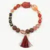 Entdecke das Buddha Love Armband – dein neuer, stylischer Begleiter! Mit seinen lebendigen roten, orangefarbenen und braunen Perlen in unterschiedlichen Größen zieht es alle Blicke auf sich. Die Buchstaben „LOVE“, eine kleine braune Quaste und ein goldener Anhänger verleihen deinem Look das gewisse Etwas. Abgerundet wird das moderne Design durch eine Buddha-Perle, die dir Ruhe und Gelassenheit schenkt. Sei mutig, sei einzigartig – setze mit diesem Armband ein echtes Statement!.