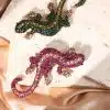 Entdecke deinen Style-Kick: Zwei mega coole Salamander-Broschen, einmal in knackigem Grün, einmal in frechem Pink – perfekt inszeniert auf angesagtem Steinfliesen und edlem Satin. Setz ein Statement und bring frischen Wind in deine Outfits!.