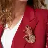Mit deinem roten Blazer und dem weißen Shirt siehst du sowieso schon stylisch aus – aber mit der Garnele-Brosche setzt du dem Ganzen die Krone auf! Die funkelnden Strasssteine in Gold, Rot, Grün und Kristall machen dein Outfit zum absoluten Hingucker. Zeig allen deinen individuellen Stil und gönn dir das gewisse Extra. Bereit für den großen Auftritt?.