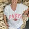 Bereit für den perfekten Paris-Look? Stell dir vor: Du strahlst pure Lebensfreude aus – mit deinem neuen weißen „Paris Vibes“ Shirt! Die rosa Buchstaben sind ein echter Hingucker und machen gute Laune, egal wo du bist. Kombiniert mit stylischen weißen Hosen und coolen Deko-Patches zeigt du der Welt, dass Mode Spaß macht. Mach's wie unser Model: Lächeln aufsetzen, Hand locker in der Hüfte und bereit für deinen ganz eigenen Fashion-Moment vor jeder urbanen Kulisse!.
