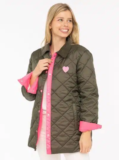 Du strahlst pure Lebensfreude aus: In deiner grünen Steppjacke mit dem leuchtend pinken Saum und dem markanten Herz-Patch setzt du ein modisches Statement. Vor dem klaren, weißen Hintergrund kommt dein Look noch stärker zur Geltung - frisch, selbstbewusst und einzigartig wie du!.