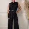 Stell dir vor, du stehst selbstbewusst vor einer hellen Wand, deren Look modern und unverwechselbar ist: Du trägst ein ärmelloses Top und eine Hose aus schwarzen Nadelstreifen, die deine Figur schmeicheln und gleichzeitig stilvolle Lässigkeit ausstrahlen. Die dezenten Trockenblumen im Hintergrund geben dem Bild einen natürlichen Touch – sie unterstreichen dein Trendbewusstsein und deine Individualität. Mit deinem strahlenden Lächeln ziehst du alle Blicke auf dich. Genau so sieht zeitgemäße Eleganz aus – klar, stark und ganz DU!.