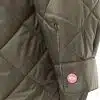 Entdecke deinen Stil: Hier zeigt sich der Ärmel einer olivgrünen Steppjacke, veredelt durch einen auffälligen pinken Knopf mit liebevollem Herz-Design. Setze ein modisches Statement und unterstreiche deine Persönlichkeit - denn jedes Detail zählt!.