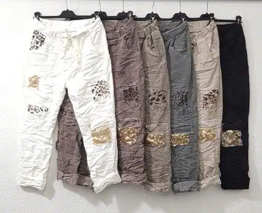 Stell dir vor, du entdeckst diese zauberhaften Patch-Hosen - sechs stylische Paare, die mit mutigen Animal-Prints und funkelnden goldenen Pailletten-Patches veredelt sind. Auf eleganten schwarzen Bügeln präsentiert, werden sie direkt zum Eyecatcher und warten nur darauf, von dir getragen zu werden. Mit diesen modernen Hosen setzt du ein echtes Fashion-Statement: selbstbewusst, individuell und absolut im Trend!.
