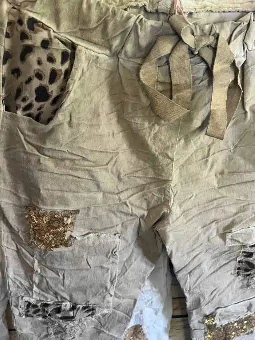 Gönn dir den ultimativen Wow-Effekt mit diesen zauberhaften, beigen Hosen! Der angesagte Wrinkle-Look trifft auf Leo-Print-Tasche und glamouröse Gold-Pailletten - so setzt du garantiert stylishe Statements. Die Stoffgürtel-Bindung betont deine Taille und macht jeden Look individuell - ob lässig oder schick, mit dieser Hose bist du immer ein Hingucker!.