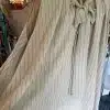 Erlebe mit der "The Line Style" Tunika einen stilvollen Auftritt: Die ärmellose, beigefarbene Bluse mit feinen Nadelstreifen und eleganter Schleifenbindung am Ausschnitt unterstreicht deine zeitlose Klasse. Präsentiert auf einer Mannequin in unserer Boutique, lädt sie dich ein, Modebewusstsein zu zeigen und jedem Look eine moderne Note zu verleihen - für starke, individuelle Frauen wie dich!.