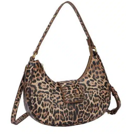 Stell dir vor, wie du mit der Wild City Bag deinen Look auf das nächste Level hebst: Das auffällige Leopardenmuster verschafft dir garantiert Hingucker-Momente in der City. Ihr modernes, geschwungenes Design schmiegt sich stilvoll an dich an und dank des praktischen Zipper-Verschlusses bleibt alles sicher verstaut. Noch mehr Flexibilität bringt dir der zusätzliche Schulterriemen - so bist du für jeden Anlass perfekt ausgestattet!.