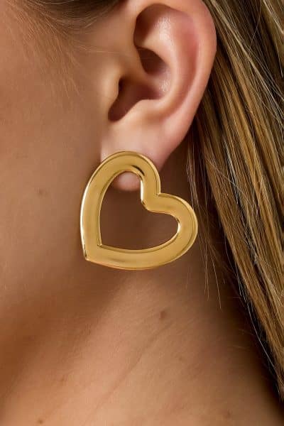 Du trägst einen großen, goldenen Open-Heart-Ohrring und die zarten Must-have Ohrstecker - modern, stilvoll und einzigartig.