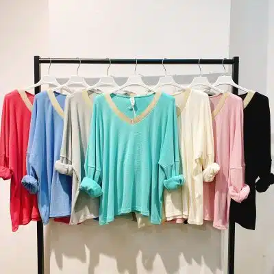 Entdecke deinen Style: Sieben V-Neck-Pullover in trendigen Farben warten am Kleiderständer auf dein neues Outfit!.