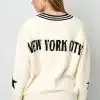 Du trägst den angesagten Varsity Star Pulli in Creme - mit "NEW YORK CITY" und coolem schwarzen Stern auf dem Rücken.