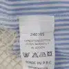 Entdecke das angesagte Label auf dem blau-weißen Stoff deiner Seaside Bluse - stylisch, informativ und perfekt für deinen Beach-Look.