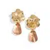 Verleihe deinem Look das gewisse Etwas mit floralen Gold-Ohrringen und pinken, transparenten Tropfen für modernen Glamour.