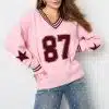 Strahle mit einem pinken Varsity Star Pulli mit "87" und trendigen Jeans, die mit schimmernden Perlen für Aufsehen sorgen.