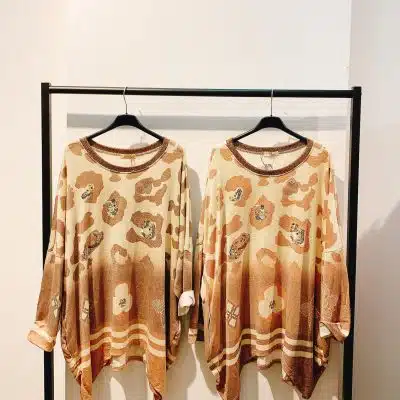Erlebe pure Leo-Luxe: Zwei Oversize-Pullis mit angesagtem Tan-Braun-Muster warten stilvoll an schwarzen Bügeln auf dich.