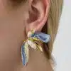 Setzen Sie ein Statement: Trage diesen modernen Ohrring mit goldenen, perlenbesetzten und blauen Blütenblättern am Ohr.
