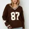 Zieh dir deinen coolen Braunpullover mit "87" und Sternen an den Ärmeln an - dazu lässige hellblaue Jeans, fertig!.