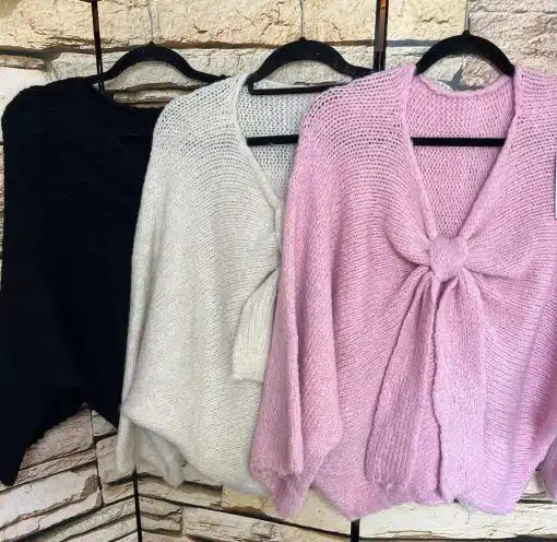 Entdecke deinen Style: Drei trendige Grobstrick-Knotenpullis in Schwarz, Creme und Rosa warten auf dich an eleganten Bügeln!.