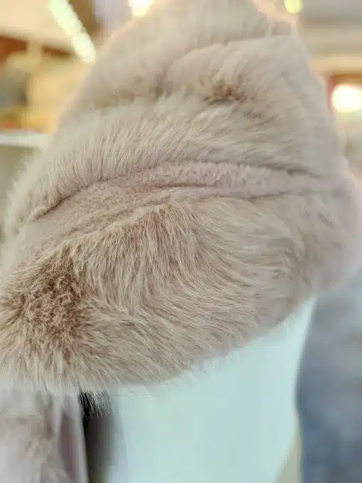 Erlebe, wie das weiche, hellbeige Kunstfell auf weißem Untergrund modernen Luxus in dein Zuhause bringt - einfach zum Wohlfühlen.