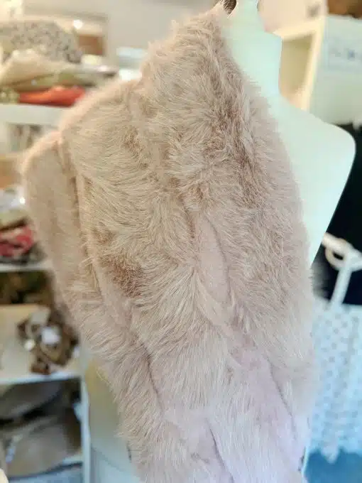Entdecke deinen neuen Look: Diese zartrosafarbene Kunstfell-Stola veredelt jedes Outfit an unserer weißen Schaufensterpuppe.