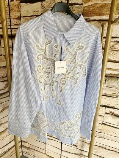 Entdecke die Seaside Bluse: Trendige Blau-Weiß-Streifen und feine, beigefarbene Spitzen-Details - für deinen modernen Look!.