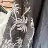 Entdecke deinen tropischen Look: Die "Tropical Elegance" Bluse mit schwarzen Palmen auf Weiß verleiht dir modernen Chic.