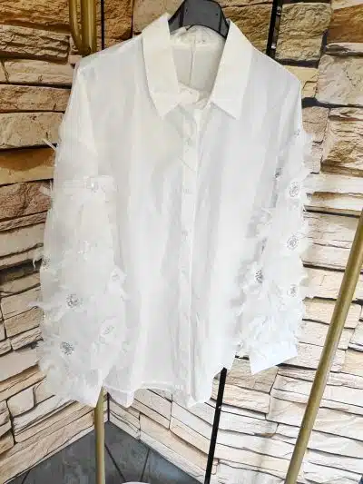 Erlebe moderne Eleganz: Die White Swan Bluse mit floralen, transparenten Ärmeln wartet auf deinen stilvollen Auftritt!.